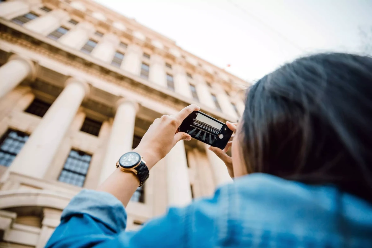 A girl taking a photo of a building